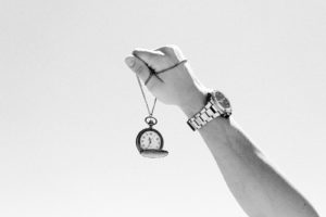 a black and white photo of a person holding a watch